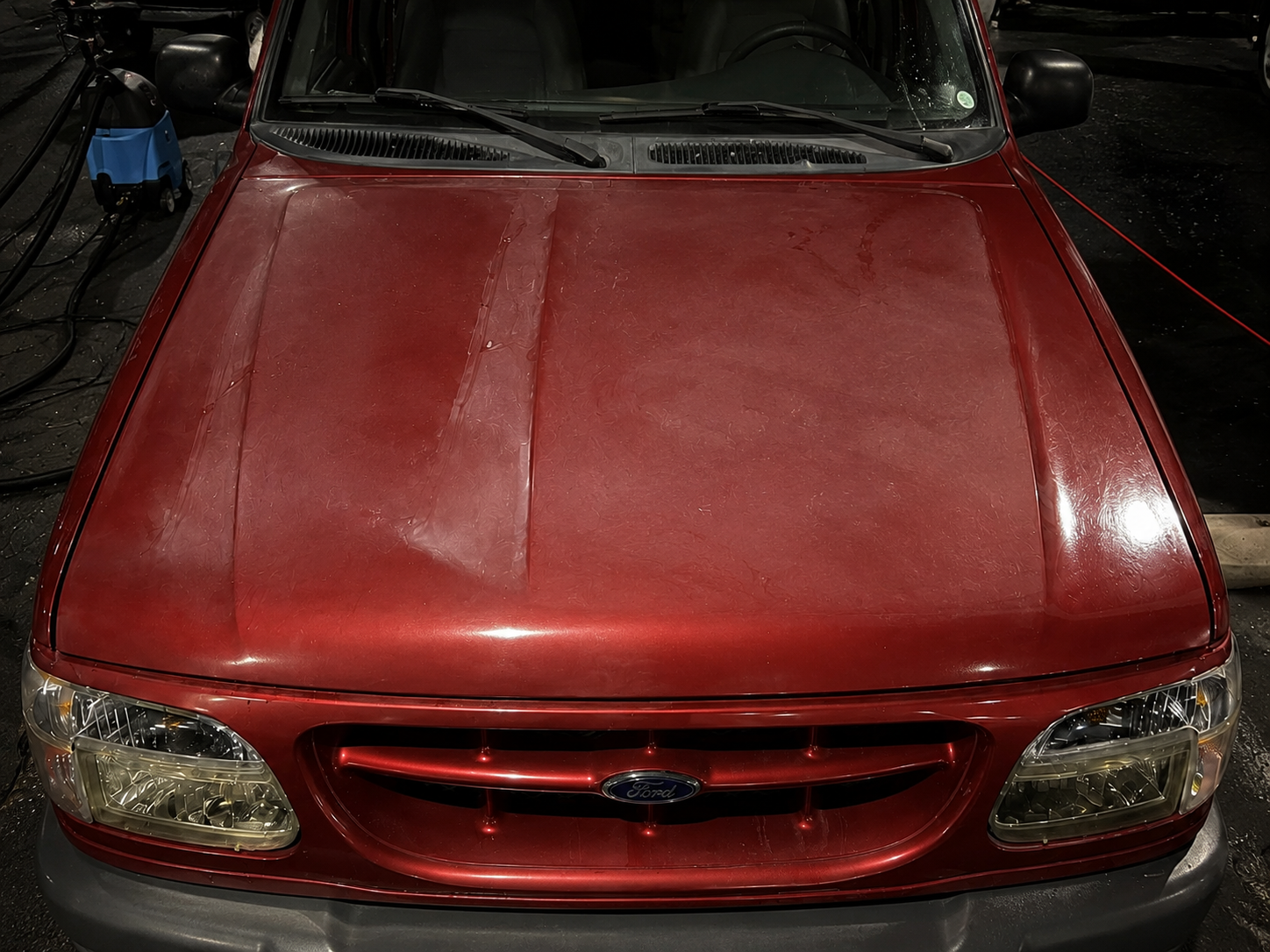 Paint correction and 7-year ceramic coating on a red Ford SUV — before